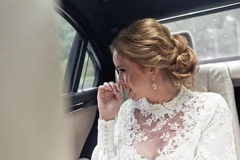 Wedding bride smiling in back-seat